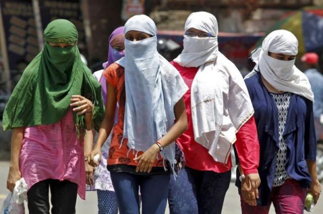 Girls, with faces covered to protect themselves from sun stroke, walk along a road on a hot summer day in Allahabad, India, May 29, 2015. REUTERS/Jitendra Prakash